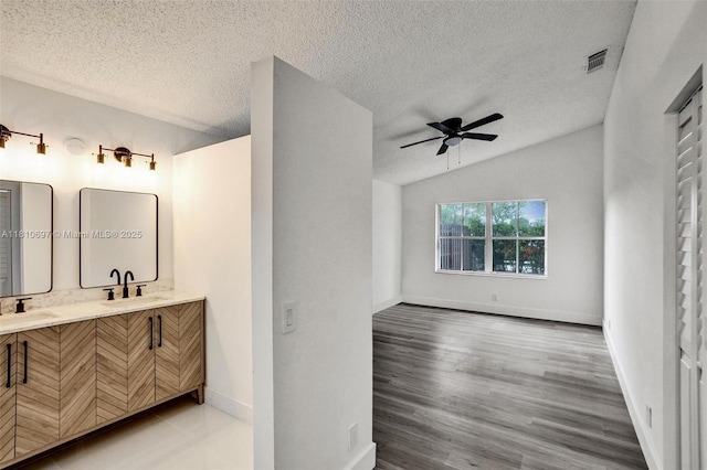 7325 Flores Way, Margate, FL 33063 - bathroom featuring double vanity, a textured ceiling, lofted ceiling, ceiling fan, and baseboards