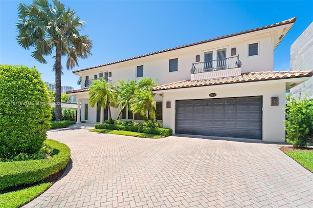 275 189th Ter, Sunny Isles Beach, FL 33160 - mediterranean / spanish-style home with a balcony, decorative driveway, stucco siding, a tile roof, and an attached garage