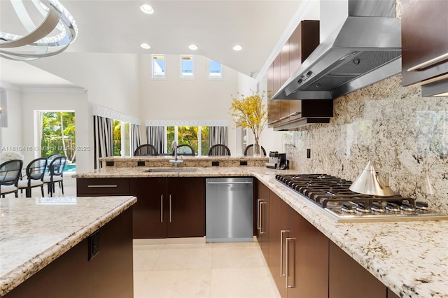 275 189th Ter, Sunny Isles Beach, FL 33160 - kitchen featuring wall chimney range hood, stainless steel appliances, a sink, a peninsula, and plenty of natural light