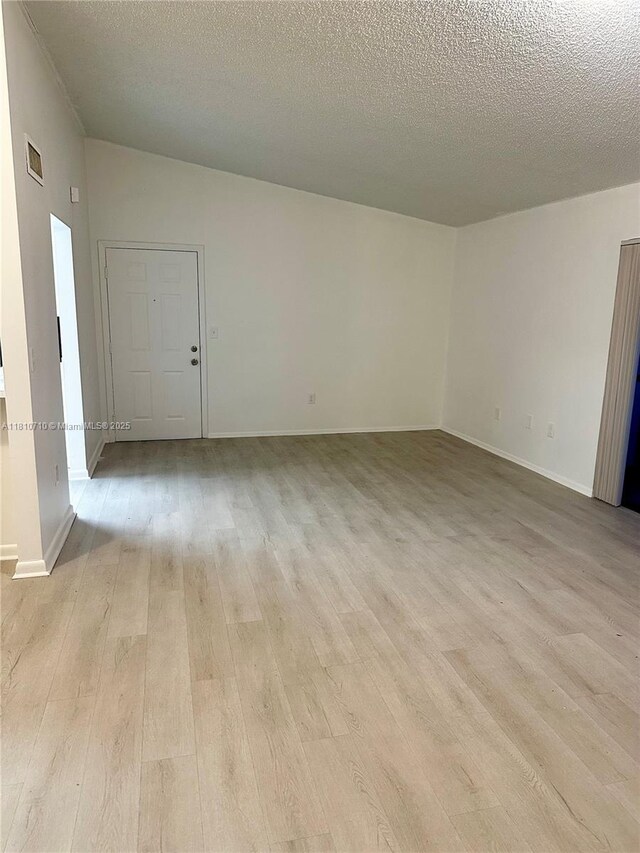 20760 NE 4th Ct Unit 201, Miami, FL 33179 - spare room featuring light wood finished floors, a textured ceiling, and baseboards