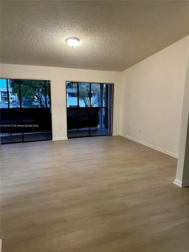 20760 NE 4th Ct Unit 201, Miami, FL 33179 - spare room with wood finished floors, baseboards, and a textured ceiling