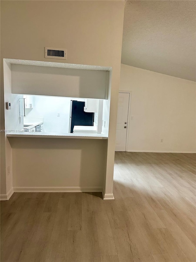 20760 NE 4th Ct Unit 201, Miami, FL 33179 - kitchen with wood finished floors, baseboards, freestanding refrigerator, and a textured ceiling