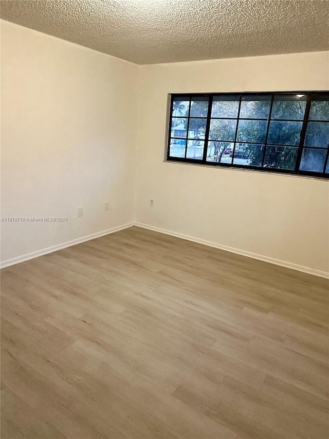 20760 NE 4th Ct Unit 201, Miami, FL 33179 - unfurnished room featuring wood finished floors, baseboards, and a textured ceiling