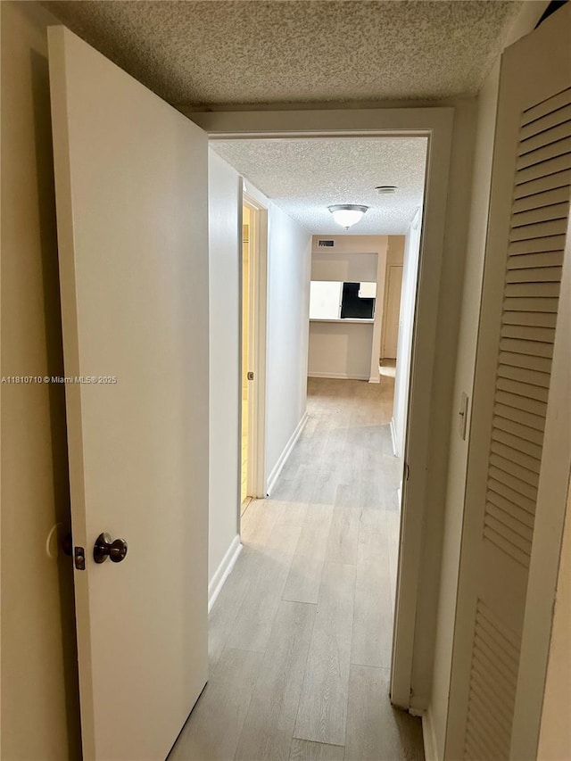 20760 NE 4th Ct Unit 201, Miami, FL 33179 - hall featuring a textured ceiling, light wood finished floors, and baseboards