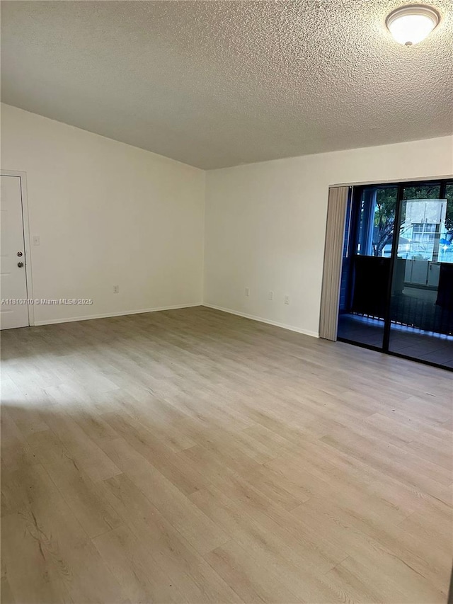 20760 NE 4th Ct Unit 201, Miami, FL 33179 - spare room with light wood-style flooring, a textured ceiling, and baseboards