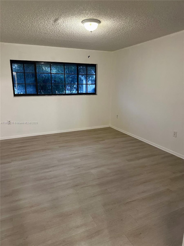 20760 NE 4th Ct Unit 201, Miami, FL 33179 - spare room featuring wood finished floors, a textured ceiling, and baseboards