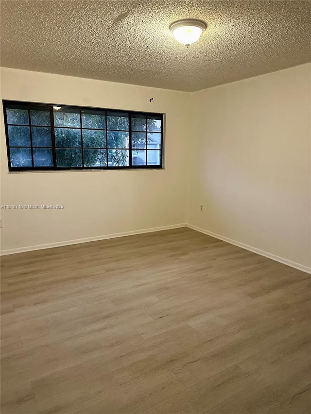 20760 NE 4th Ct Unit 201, Miami, FL 33179 - spare room with a textured ceiling, wood finished floors, and baseboards