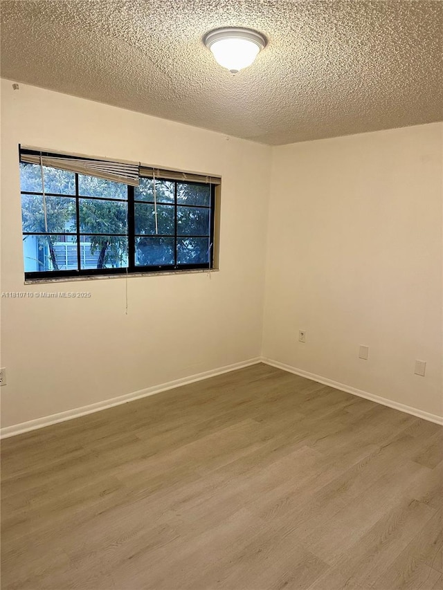 20760 NE 4th Ct Unit 201, Miami, FL 33179 - empty room featuring wood finished floors, a textured ceiling, and baseboards