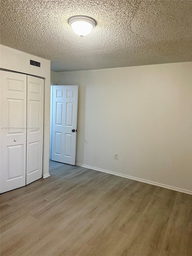 20760 NE 4th Ct Unit 201, Miami, FL 33179 - unfurnished bedroom with wood finished floors, a closet, a textured ceiling, and baseboards