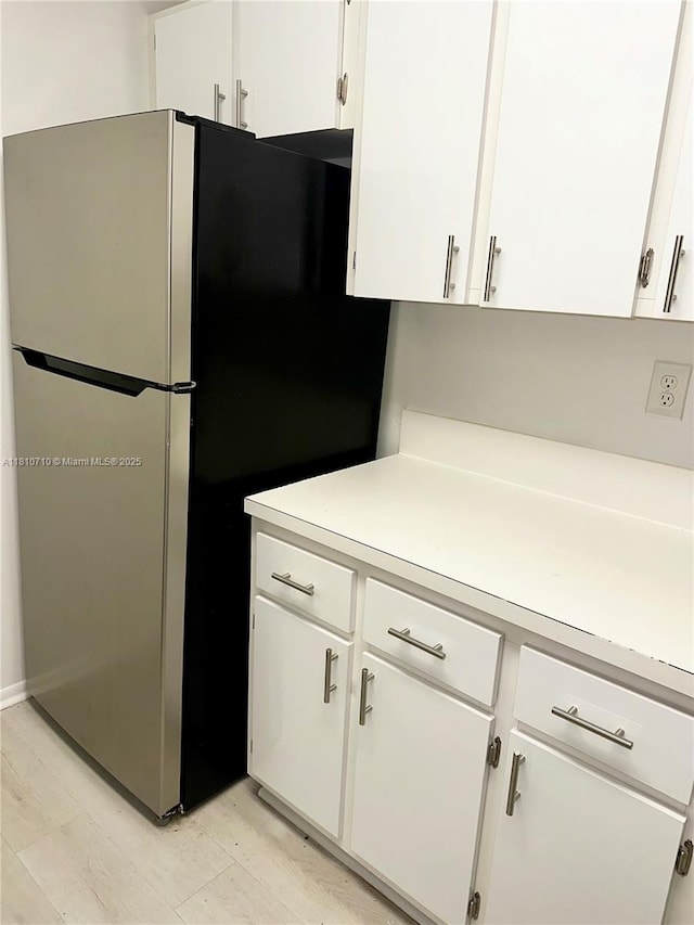 20760 NE 4th Ct Unit 201, Miami, FL 33179 - kitchen featuring freestanding refrigerator, light countertops, and white cabinetry