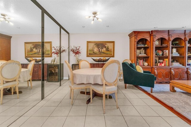 13731 SW 103rd Ter, Miami, FL 33186 - dining area featuring a textured ceiling, a chandelier, and light tile patterned floors