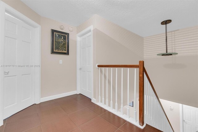 13731 SW 103rd Ter, Miami, FL 33186 - hallway with an upstairs landing, a textured ceiling, and tile patterned flooring