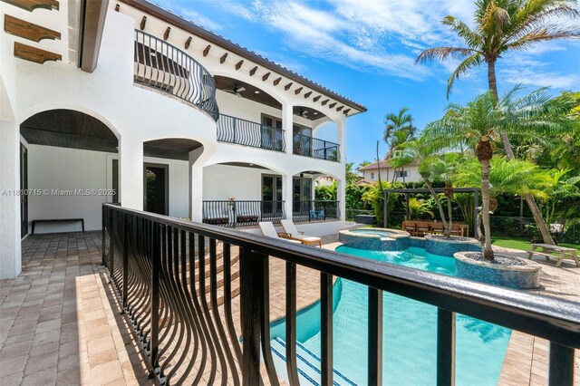 1210 95th St, Bay Harbor Islands, FL 33154 - back of property with a balcony, a patio area, a pool with connected hot tub, stucco siding, and ceiling fan