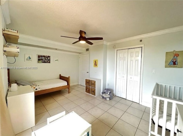 1650 Coral Way Unit 403, Miami, FL 33145 - bedroom with crown molding, light tile patterned floors, a closet, a ceiling fan, and a textured ceiling