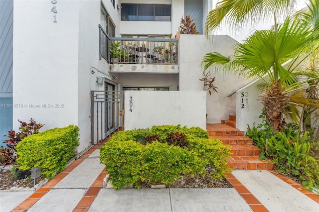 8341 SW 157th Ave Unit 304, Miami, FL 33193 - view of exterior entry with a balcony, a gate, and stucco siding