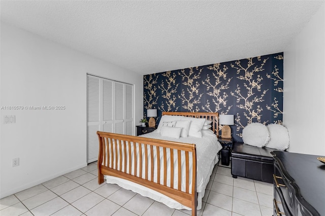 8341 SW 157th Ave Unit 304, Miami, FL 33193 - bedroom with wallpapered walls, a textured ceiling, a closet, and tile patterned flooring