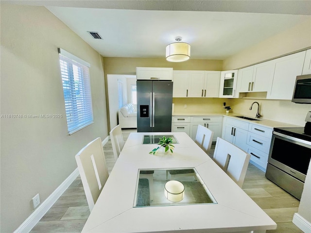 1002 S 27th Ave, Hollywood, FL 33020 - kitchen with appliances with stainless steel finishes, a sink, white cabinetry, and light countertops