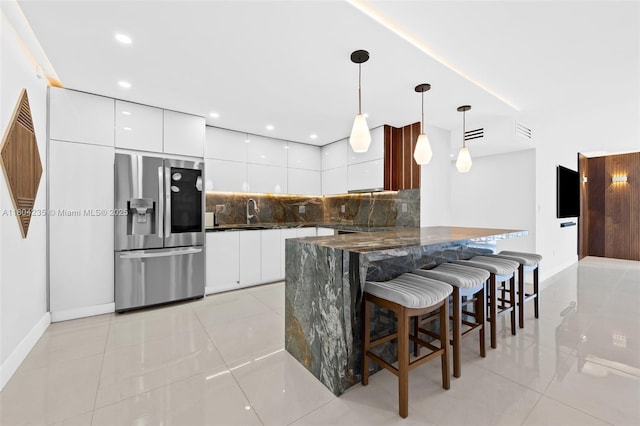 1501 S Ocean Dr Unit 1005, Hollywood, FL 33019 - kitchen with stainless steel fridge, modern cabinets, tasteful backsplash, a kitchen breakfast bar, and light tile patterned flooring