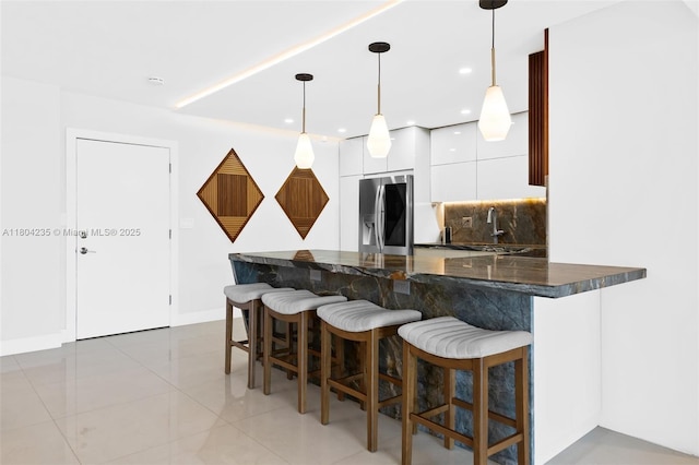 1501 S Ocean Dr Unit 1005, Hollywood, FL 33019 - kitchen with stainless steel fridge, white cabinetry, a kitchen bar, modern cabinets, and backsplash