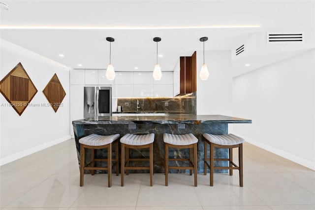 1501 S Ocean Dr Unit 1005, Hollywood, FL 33019 - kitchen with stainless steel refrigerator with ice dispenser, modern cabinets, decorative backsplash, white cabinetry, and dark stone counters