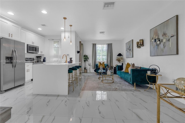 1901 SW 60th Ter, North Lauderdale, FL 33068 - kitchen featuring appliances with stainless steel finishes, a kitchen breakfast bar, light marble finish floors, recessed lighting, and white cabinetry
