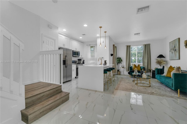 1901 SW 60th Ter, North Lauderdale, FL 33068 - kitchen featuring appliances with stainless steel finishes, open floor plan, a kitchen bar, light marble finish floors, and recessed lighting