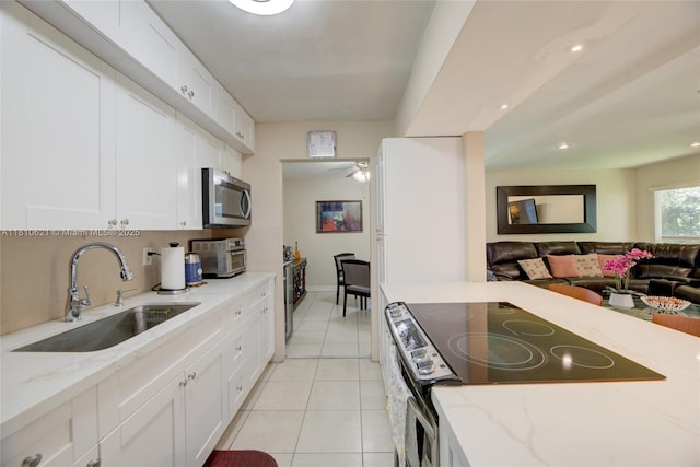 7201 NW 67th St, Tamarac, FL 33321 - kitchen with a sink, range with electric stovetop, stainless steel microwave, white cabinetry, and open floor plan