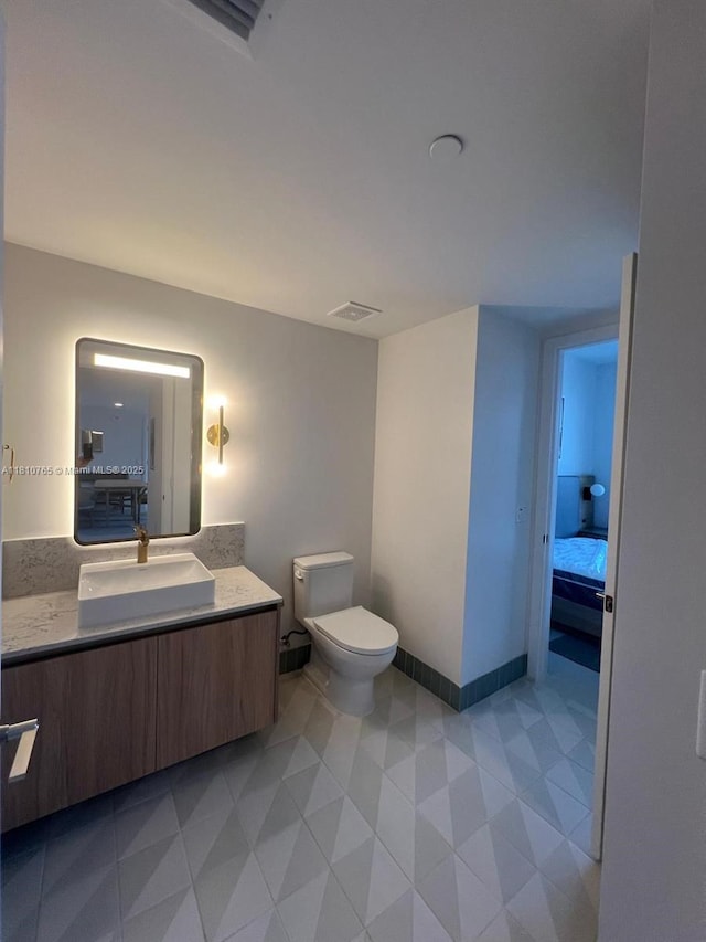 601 NE 1st Ave Unit 3205, Miami, FL 33132 - bathroom featuring vanity, toilet, connected bathroom, and baseboards