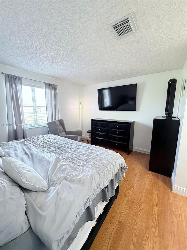 15741 SW 137th Ave Unit 206, Miami, FL 33177 - bedroom with a textured ceiling, light wood-type flooring, and baseboards