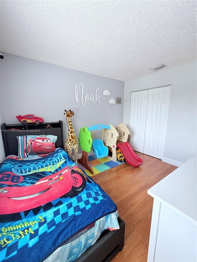 15741 SW 137th Ave Unit 206, Miami, FL 33177 - bedroom featuring wood finished floors, a textured ceiling, and a closet