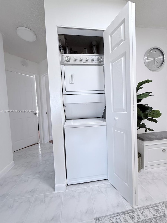 15741 SW 137th Ave Unit 206, Miami, FL 33177 - laundry area featuring light marble finish flooring, stacked washer and clothes dryer, and baseboards