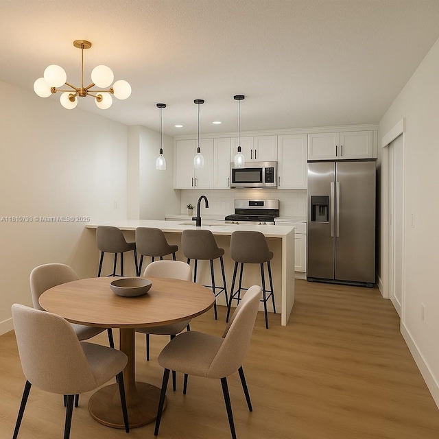 120 Heritage Way, West Palm Beach, FL 33407 - dining room featuring light wood-style floors, a chandelier, and baseboards