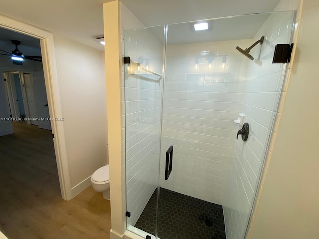 120 Heritage Way, West Palm Beach, FL 33407 - bathroom featuring wood finished floors, a shower stall, toilet, ceiling fan, and baseboards