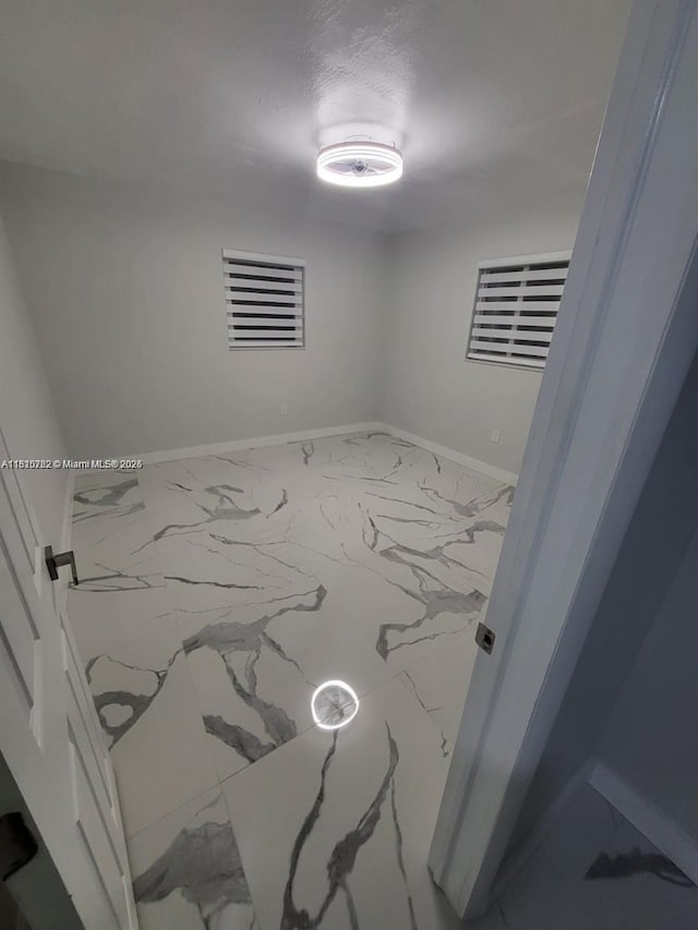 6275 Palm Ave, Hialeah, FL 33012 - empty room with marble look tiles and baseboards
