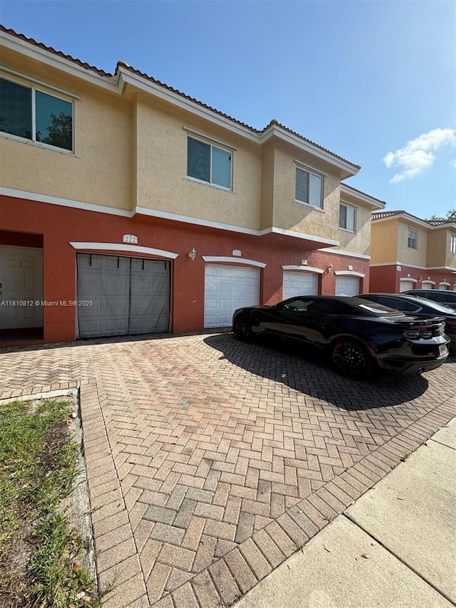 3340 Palomino Dr Unit 211-2, Davie, FL 33024 - townhome / multi-family property with an attached garage, driveway, stucco siding, and a tiled roof