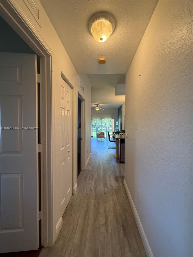 3340 Palomino Dr Unit 211-2, Davie, FL 33024 - hallway with wood finished floors, baseboards, a textured ceiling, and a textured wall