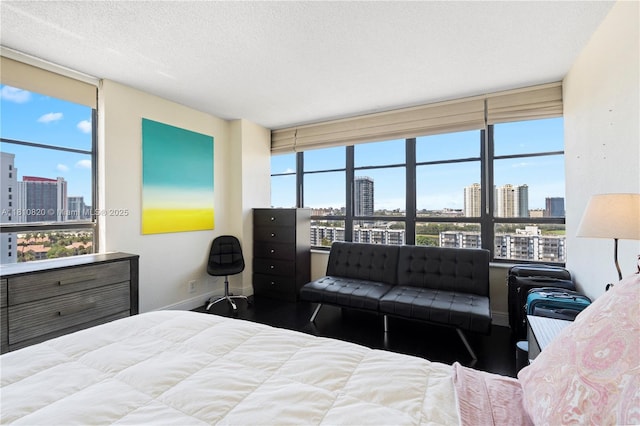 500 Three Islands Blvd Unit 1112, Hallandale Beach, FL 33009 - bedroom with a view of skyline, wood finished floors, baseboards, a textured ceiling, and a wall of windows