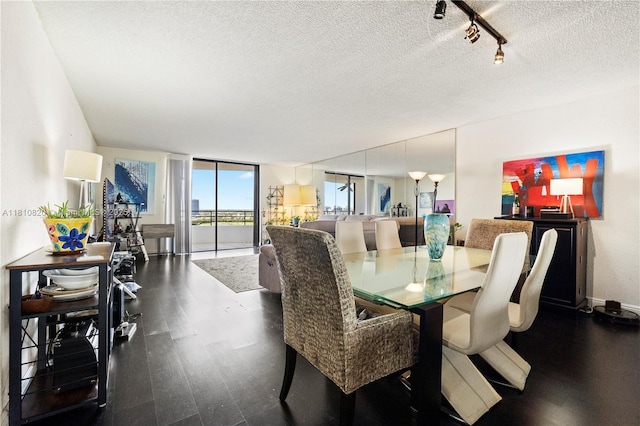 500 Three Islands Blvd Unit 1112, Hallandale Beach, FL 33009 - dining room featuring dark wood finished floors, a textured ceiling, track lighting, and baseboards