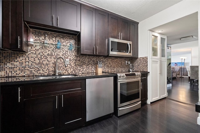 500 Three Islands Blvd Unit 1112, Hallandale Beach, FL 33009 - kitchen featuring appliances with stainless steel finishes, a sink, dark countertops, dark wood finished floors, and dark brown cabinets