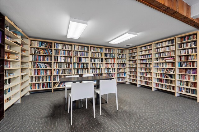 500 Three Islands Blvd Unit 1112, Hallandale Beach, FL 33009 - miscellaneous room with wall of books and carpet