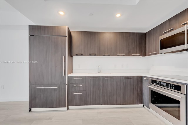 45 SW 9th St Unit 2105, Miami, FL 33130 - kitchen with appliances with stainless steel finishes, a sink, modern cabinets, light countertops, and dark brown cabinetry