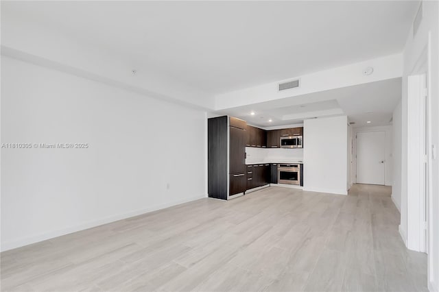 45 SW 9th St Unit 2105, Miami, FL 33130 - unfurnished living room featuring light wood-style flooring, a tray ceiling, baseboards, and recessed lighting