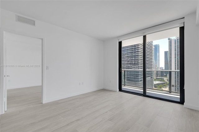 45 SW 9th St Unit 2105, Miami, FL 33130 - spare room featuring expansive windows, a view of city, baseboards, and light wood finished floors