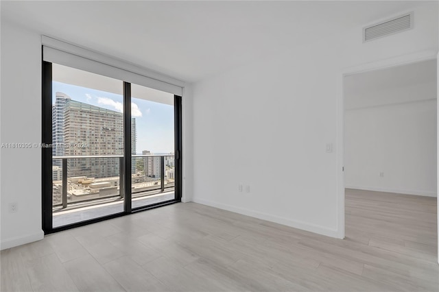 45 SW 9th St Unit 2105, Miami, FL 33130 - empty room with expansive windows, light wood-style floors, and baseboards