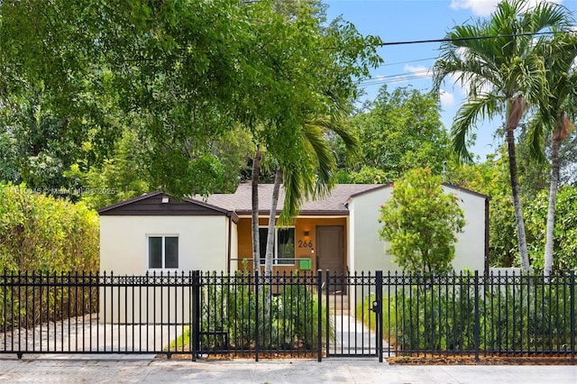 266 NW 42nd St, Miami, FL 33127 - view of front of house with stucco siding, a fenced front yard, a gate, and roof with shingles