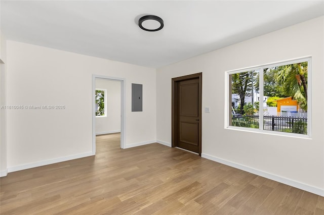 266 NW 42nd St, Miami, FL 33127 - empty room with electric panel, healthy amount of natural light, light wood-type flooring, and baseboards