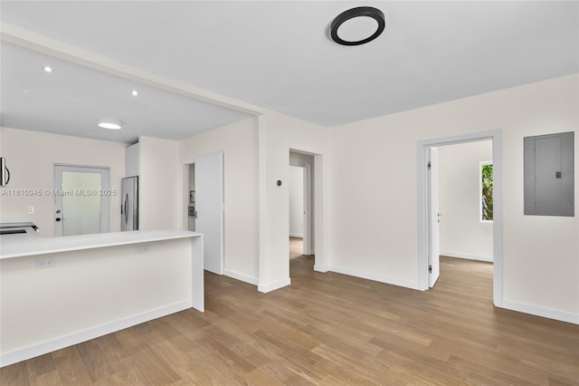 266 NW 42nd St, Miami, FL 33127 - unfurnished living room with electric panel, light wood finished floors, and baseboards