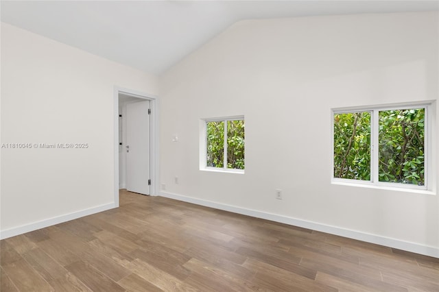 266 NW 42nd St, Miami, FL 33127 - unfurnished room featuring vaulted ceiling, wood finished floors, and baseboards