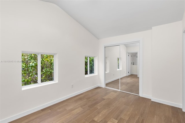 266 NW 42nd St, Miami, FL 33127 - unfurnished bedroom with multiple windows, wood finished floors, a closet, baseboards, and high vaulted ceiling