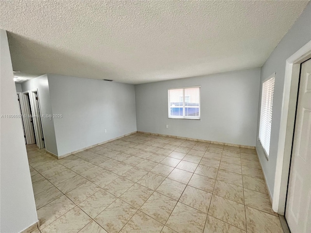 281 NW 51st Ave, Miami, FL 33126 - unfurnished room featuring a textured ceiling, light tile patterned floors, and baseboards